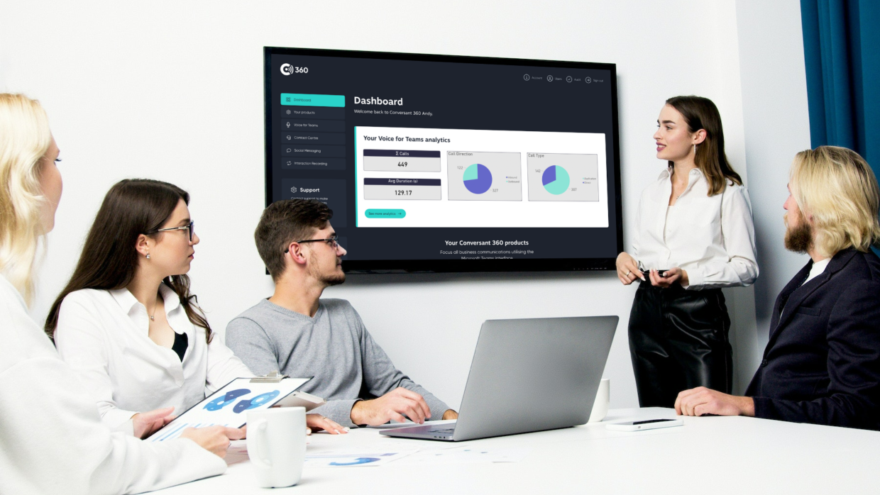 Workers in a meeting room looking at a presentaion on the screen