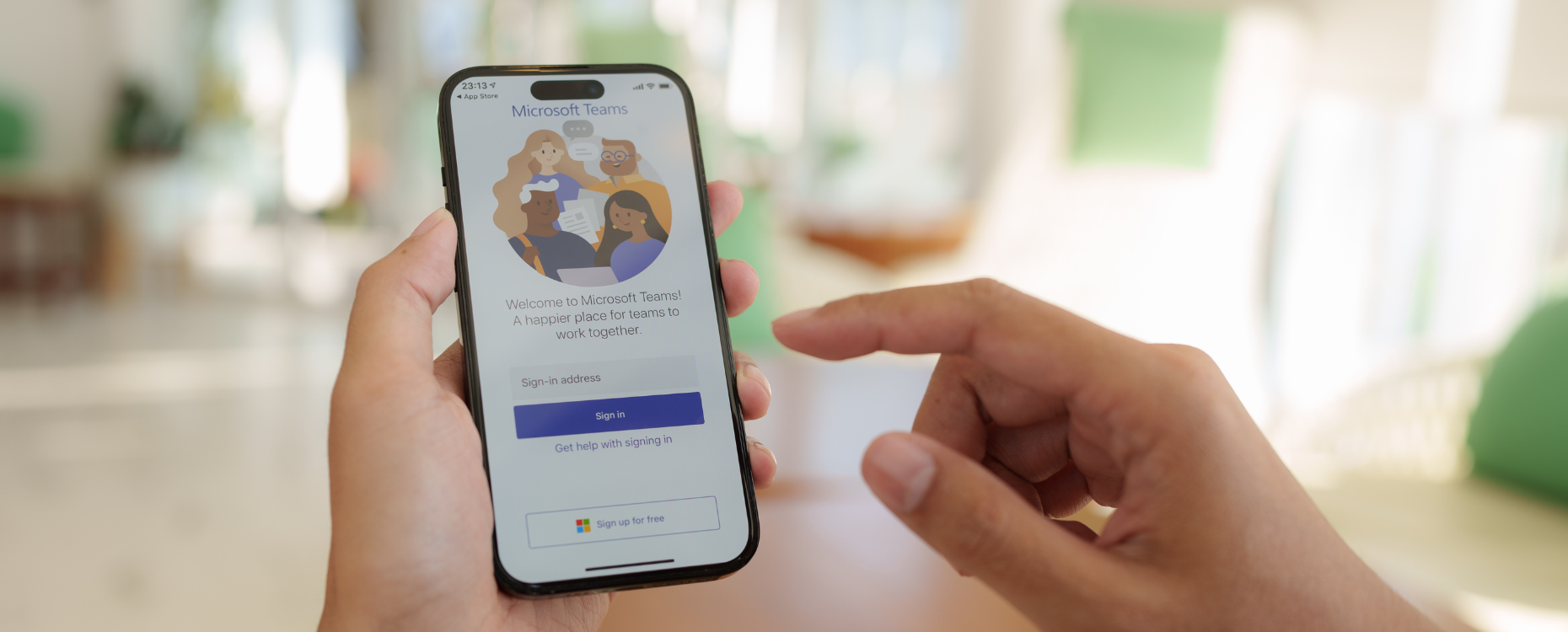 Hands holding a mobile phone signing into Microsoft Teams